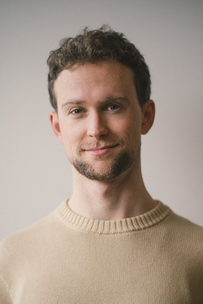Portrait of Blake Rupert in a cream sweater, photographed in natural indoor light.